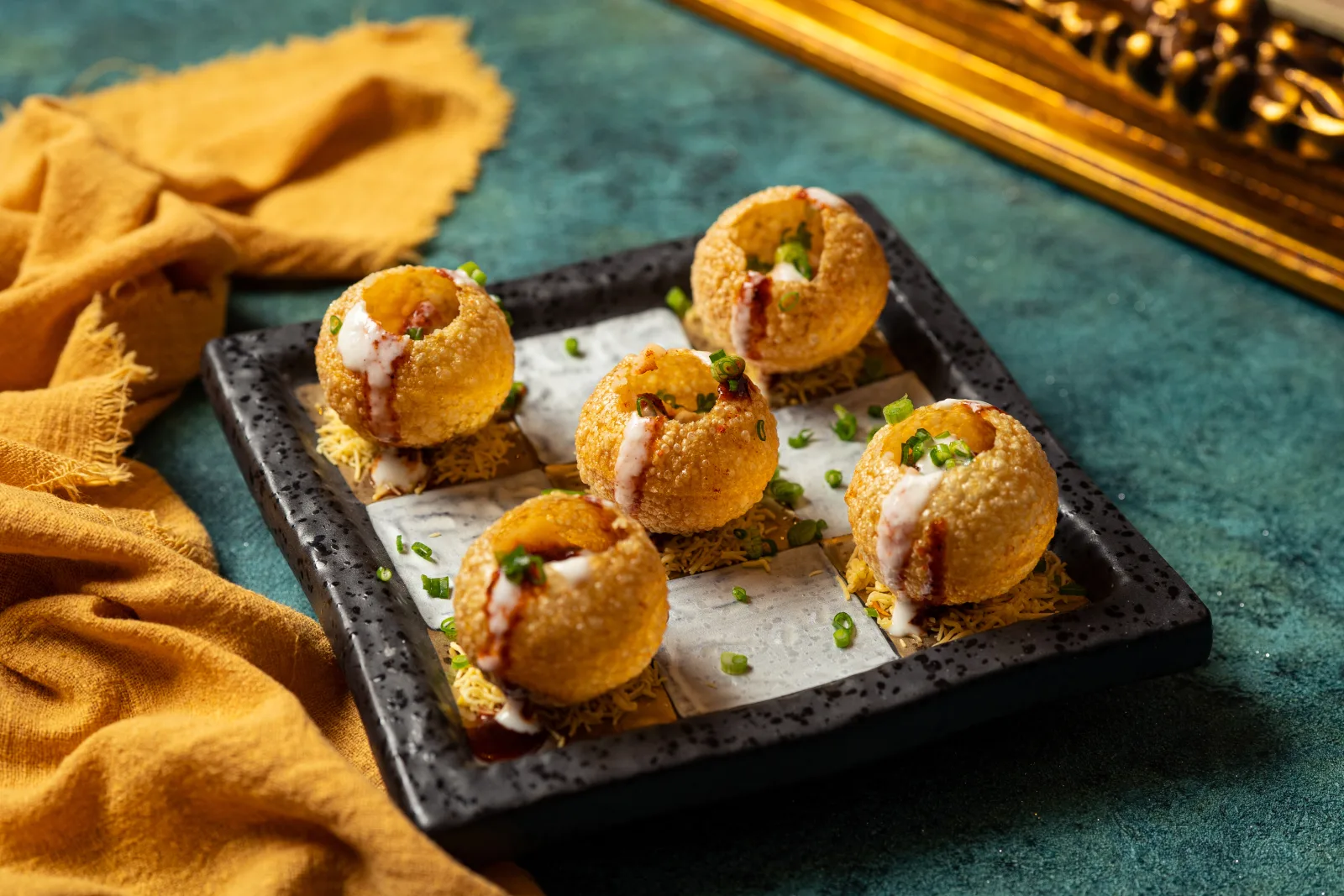 Dahi puri finished with yogurt and sev