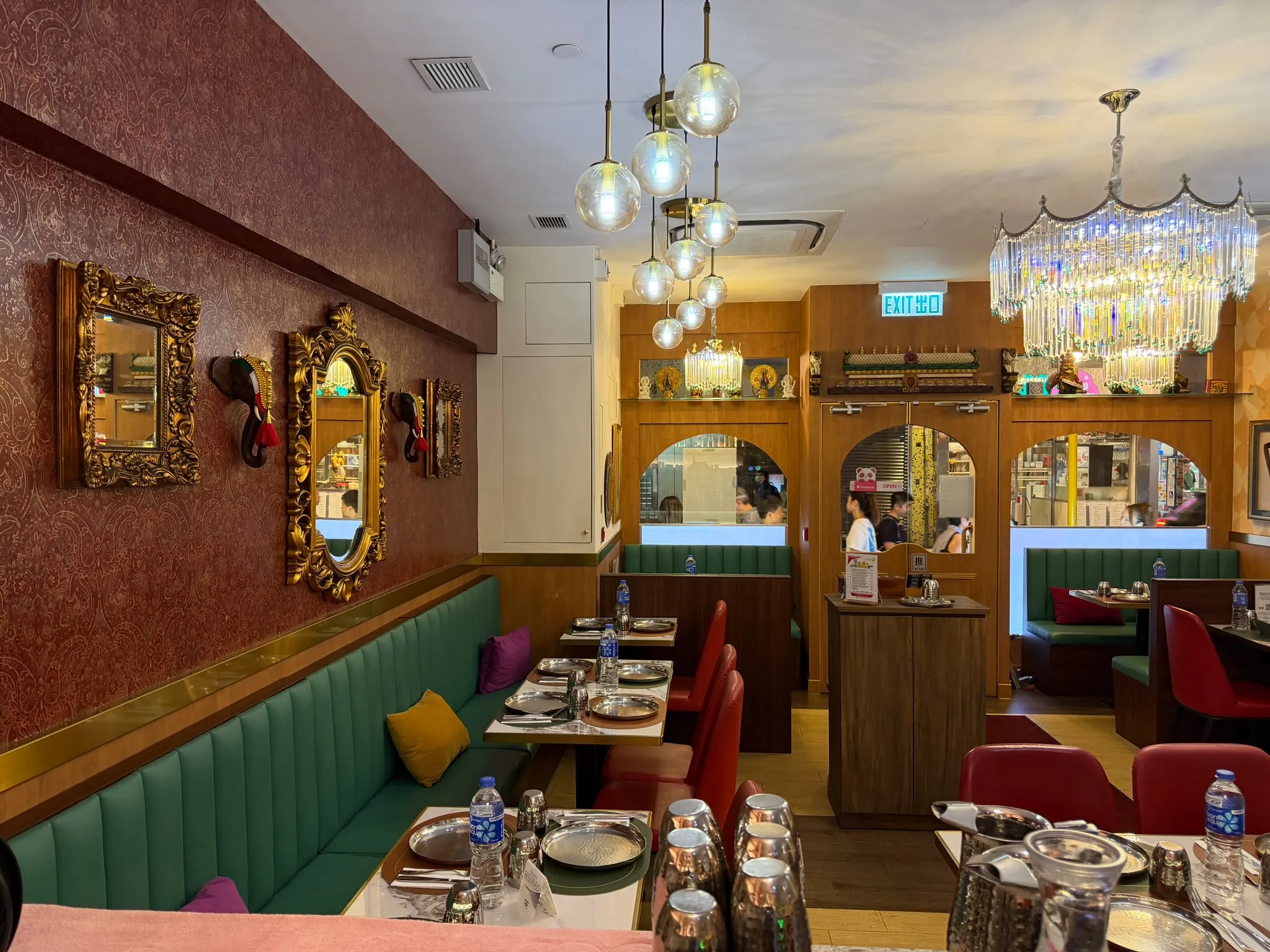 The Tulsi dining room wall - ornate red patterned wallpaper with gold-framed mirrors